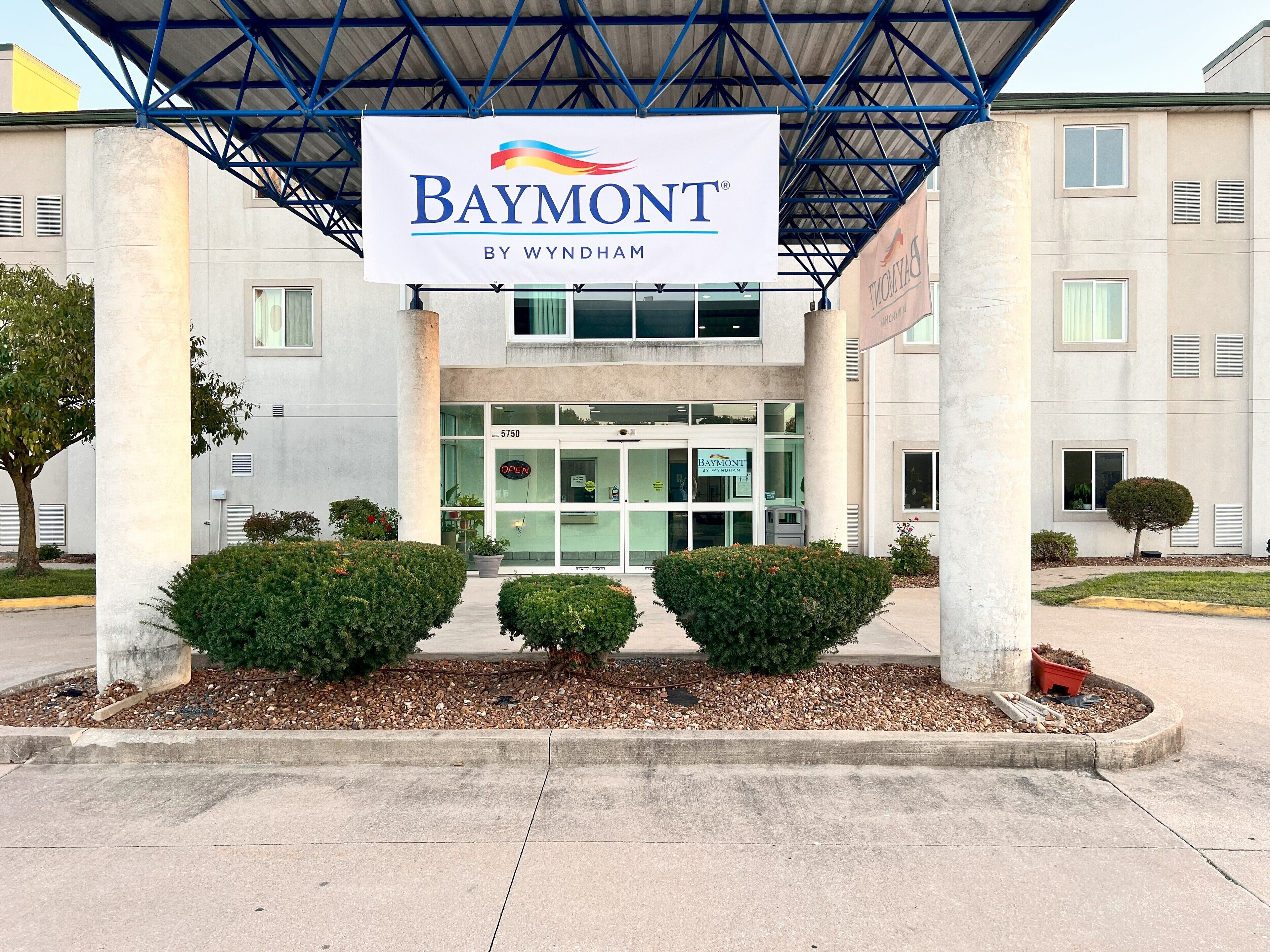 En byggnad med en skylt där det står ”Baymont by Wyndham” och numret ”5750” på dörren.