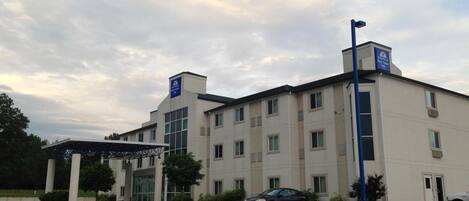 A multi-story hotel with a covered entrance and a parking lot.