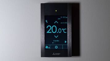 Un thermostat numérique affiche une température de 20,0 °C, l’heure est 12h32, et le mot « Veille » apparaît sous la température.