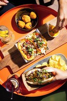 Una bandeja con diversos alimentos, como tacos, totopos y una bebida.