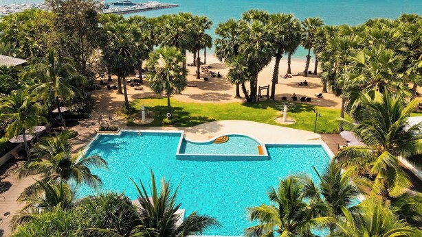 A pool area with a view of the beach and ocean.