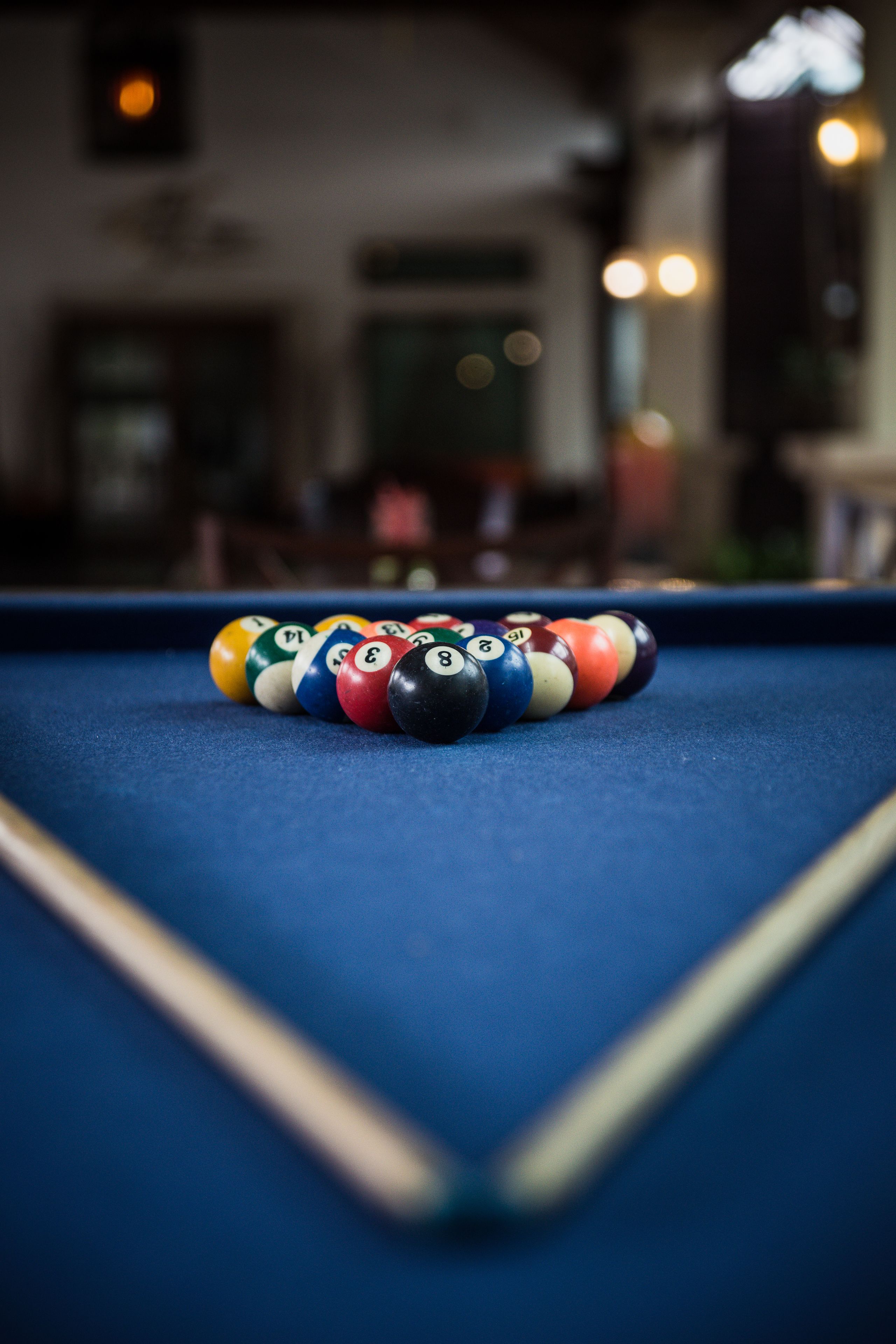 A pool table with a set of billiard balls arranged in a triangle formation.