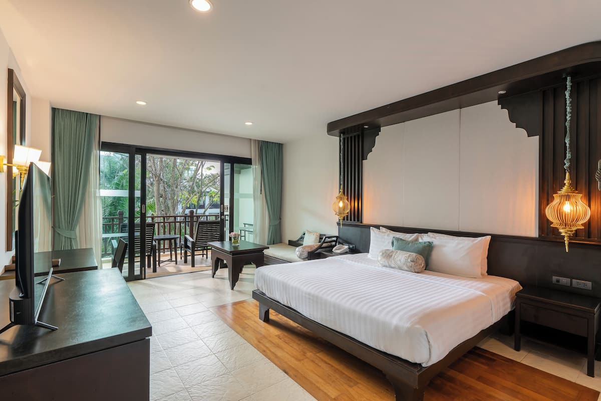Quarto de hotel moderno com uma cama grande, uma escrivaninha e vista para o exterior.