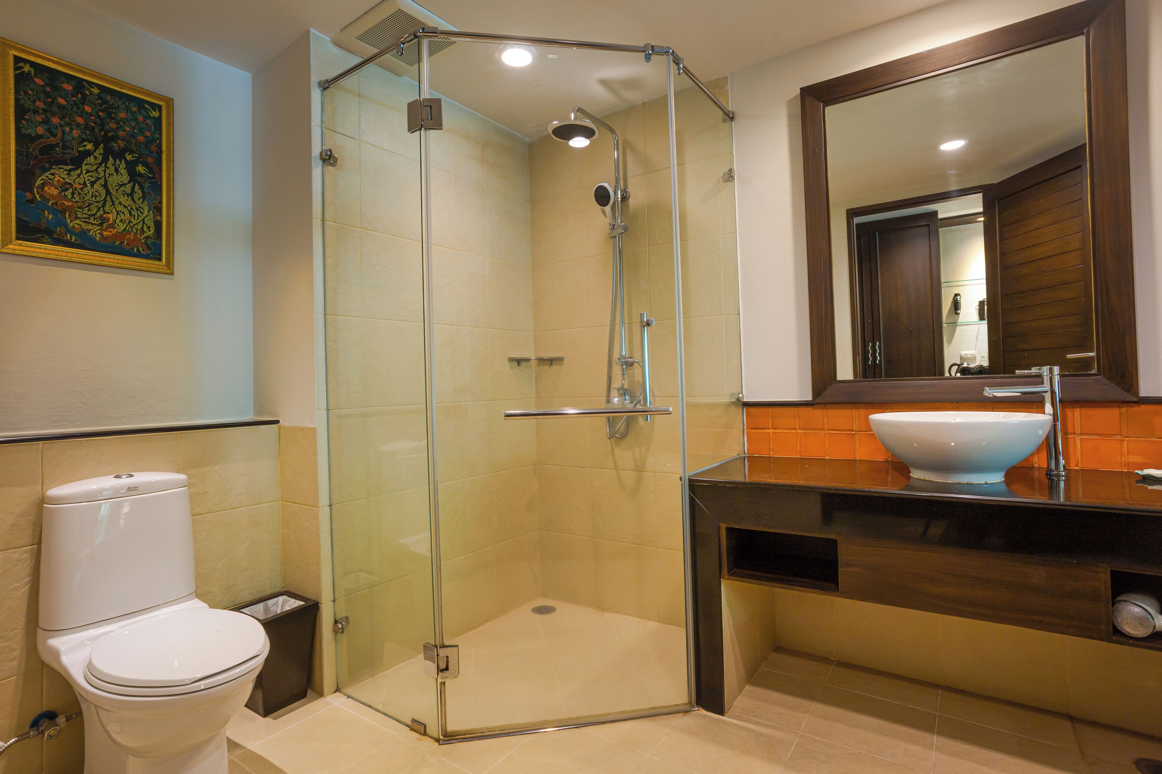 A bathroom with a glass-enclosed shower, a white toilet, and a sink with a large mirror above it.