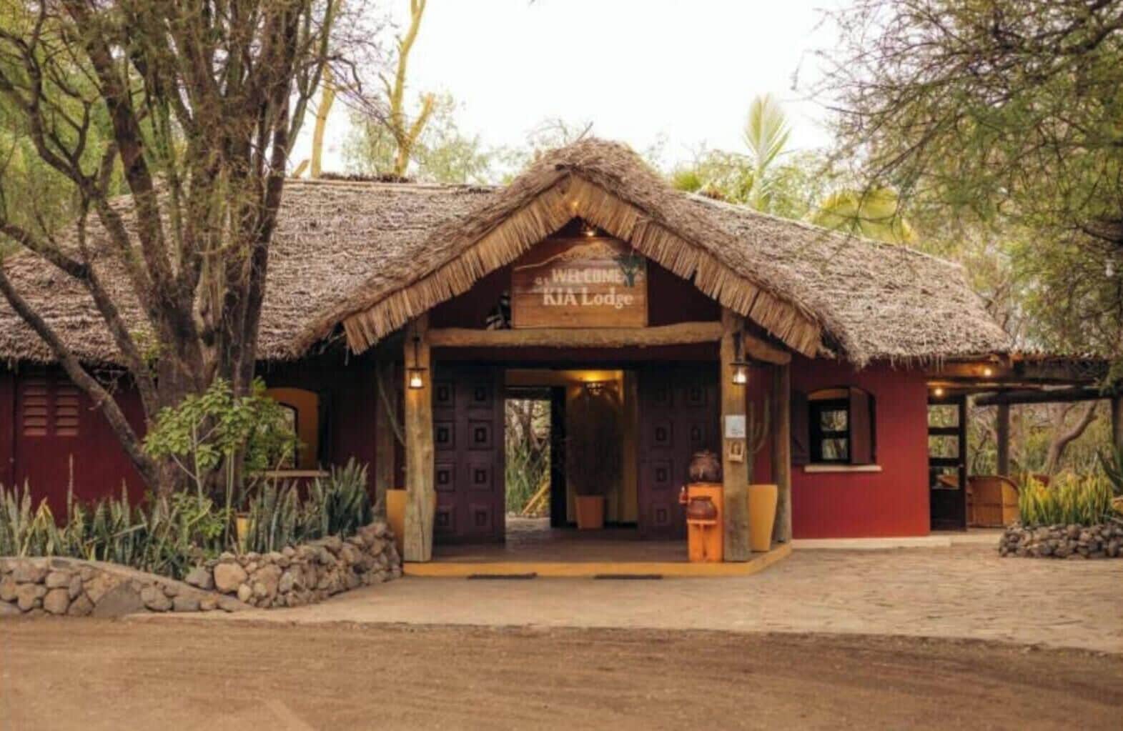 Una construcción con techo de paja y un cartel que dice "KiA Lodge".