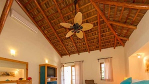 A bedroom with a wooden ceiling, a bed, a TV, and a wardrobe. - Hotel Tripui (Loreto)