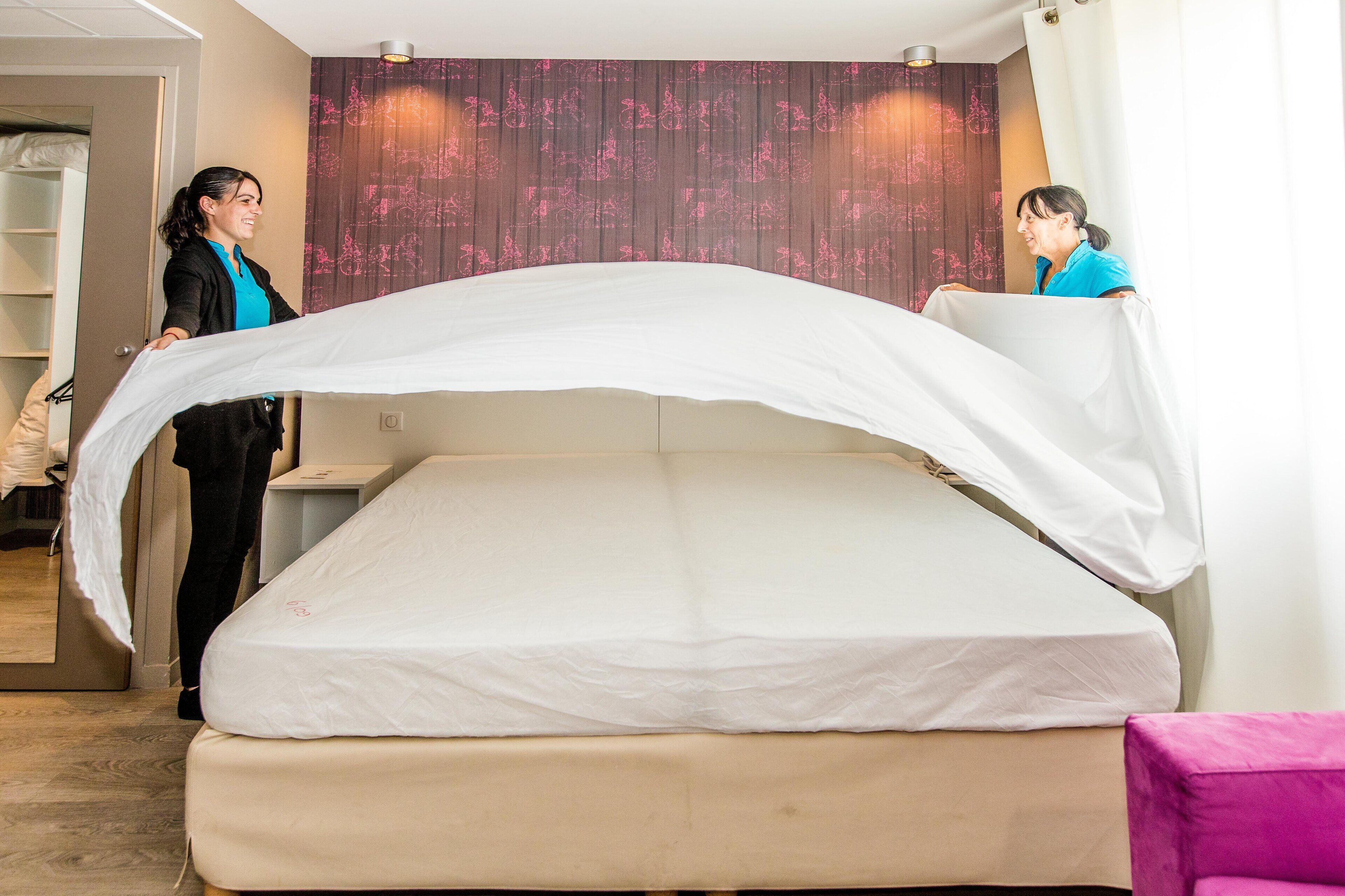 A bedroom with a bed, a nightstand, and a wardrobe.