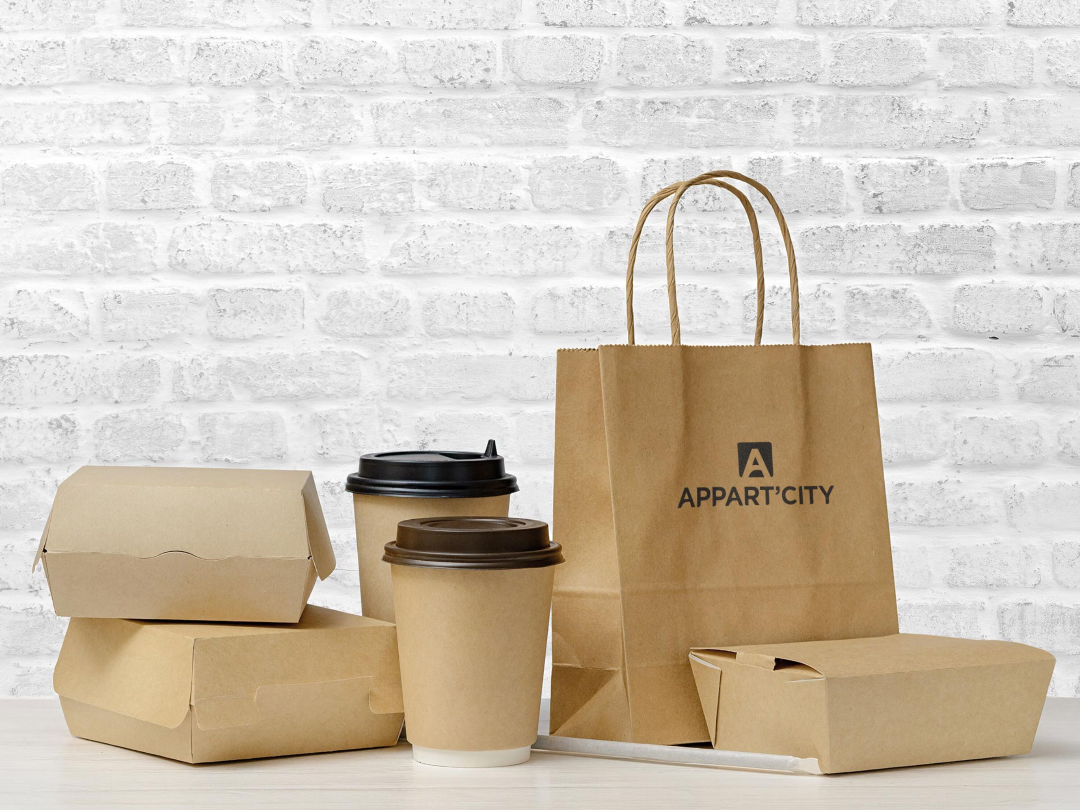 Kartonkartons, Papierbecher und eine braune Papiertüte mit dem Aufdruck 'APPART'.
