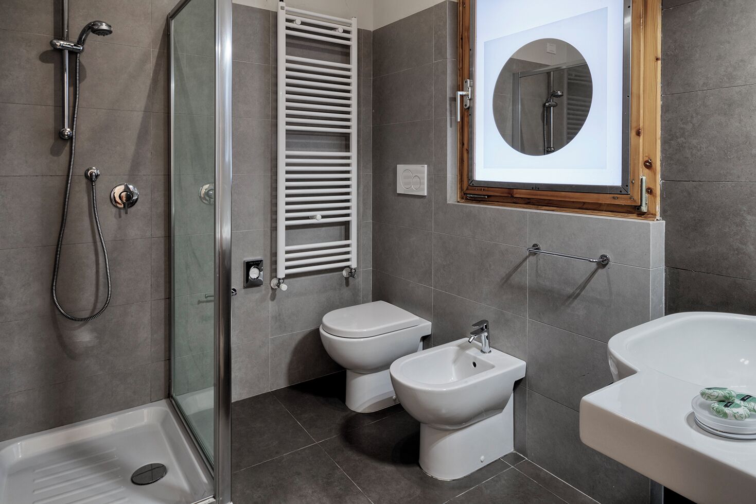 Une salle de bain moderne équipée d’une douche, de toilettes, d’un bidet et d’un lavabo.