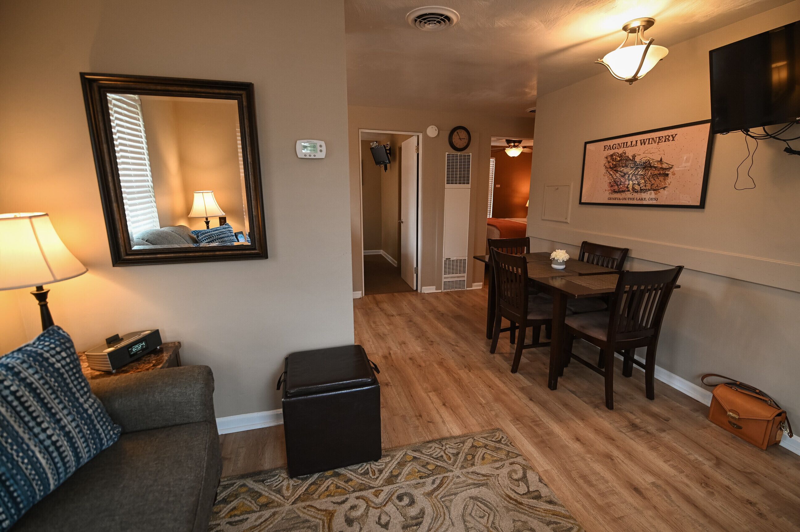 A living room with a sofa, a coffee table, a TV, and a dining area with a table and chairs.
