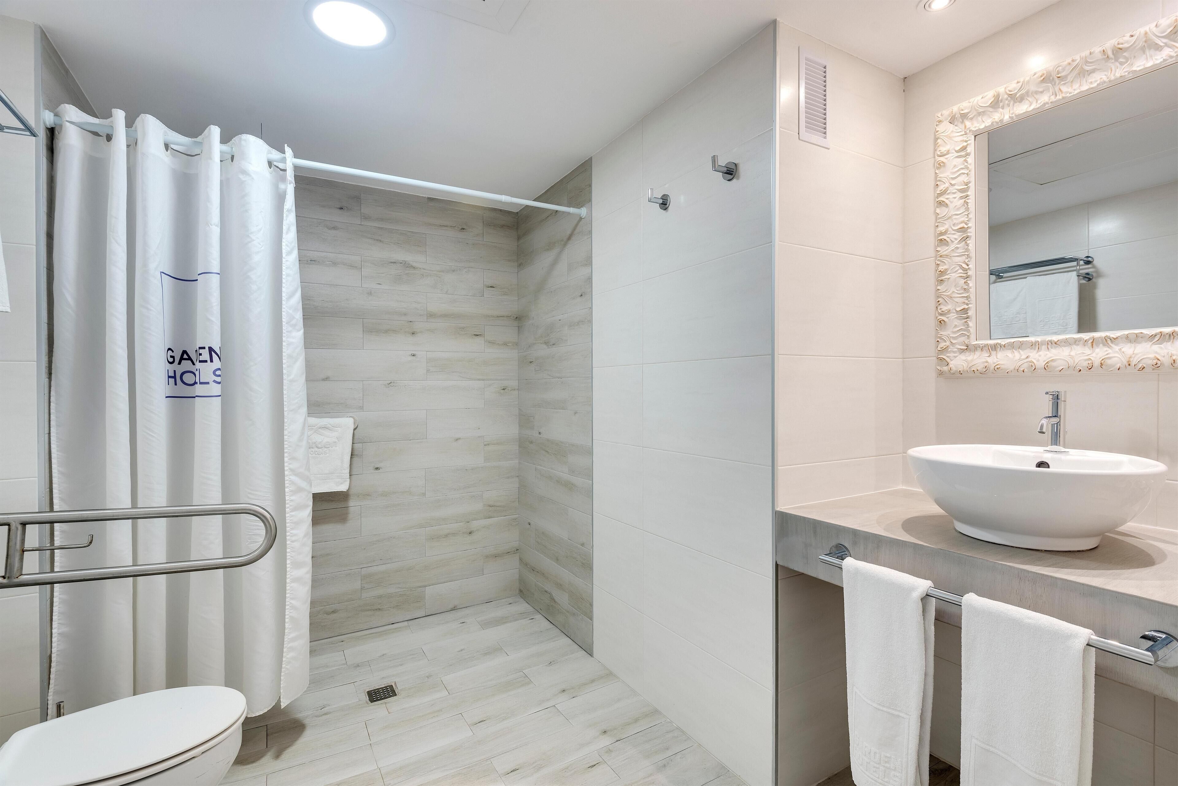 A modern bathroom with a shower, toilet, and sink.