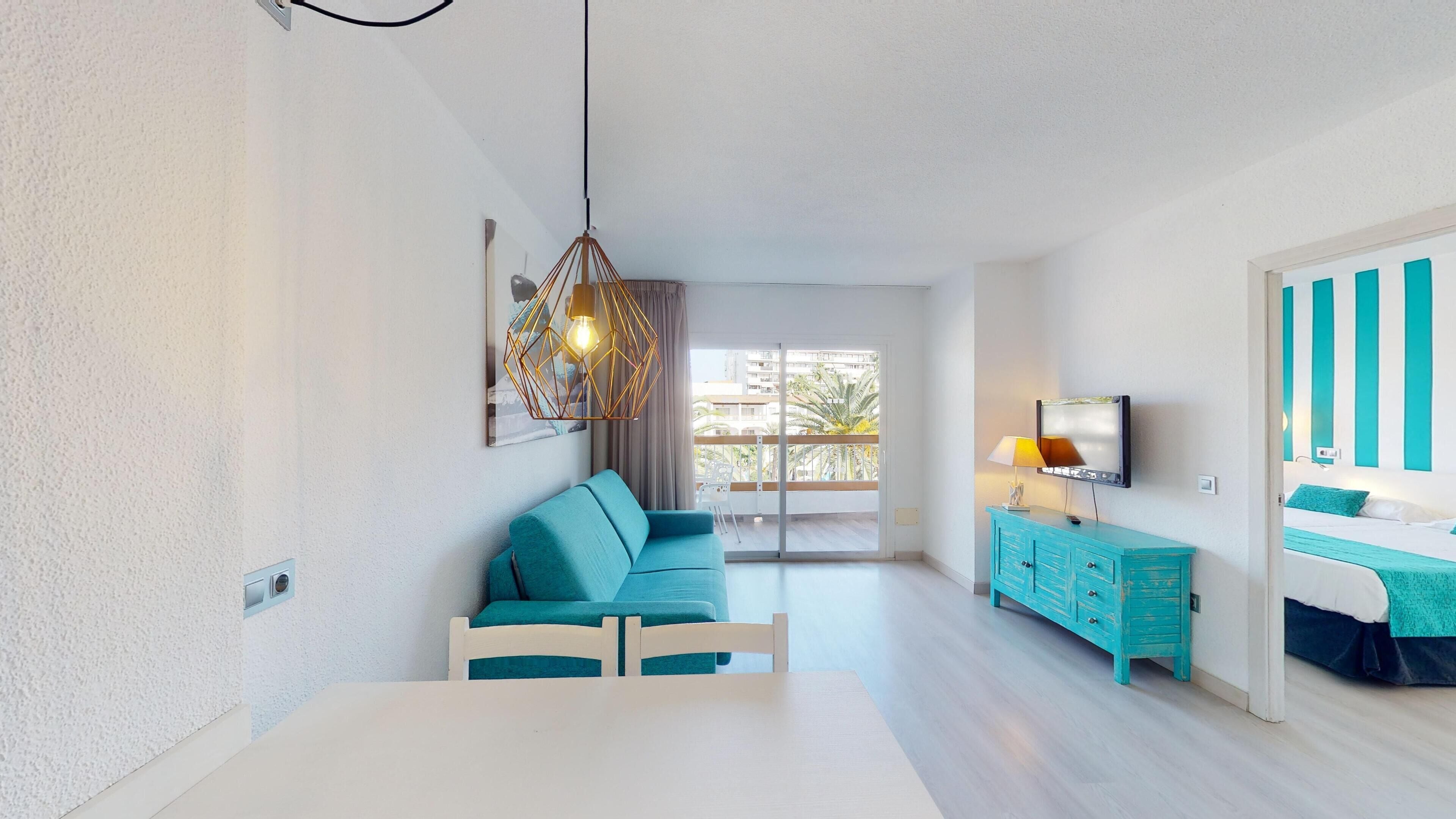 A modern living room with a sofa, a dining table, and a TV.