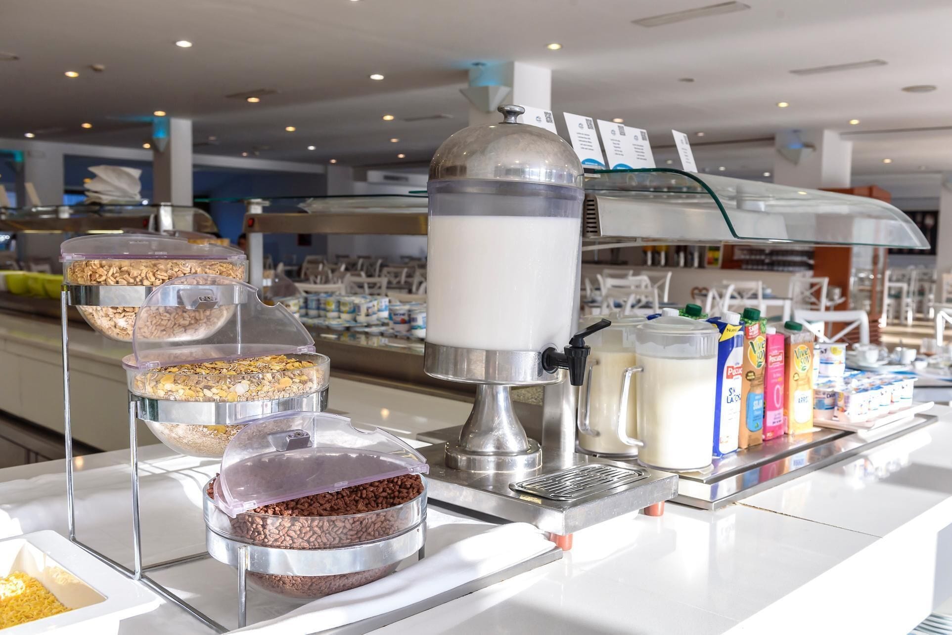 A self-serve coffee station with multiple dispensers for coffee, milk, and creamer.