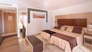 Una habitación de hotel moderna con una cama grande, un sofá y una pequeña mesa.