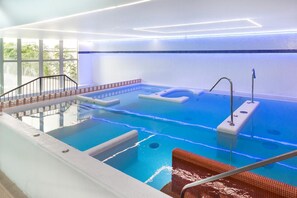 Una piscina al aire libre, sillones reclinables de piscina