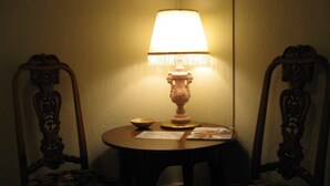 Une table avec une lampe, deux chaises et un bol.
