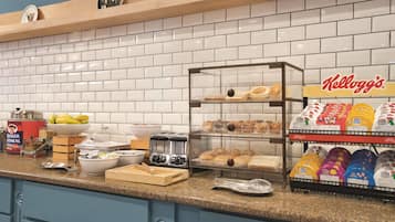 Ein Frühstücksbuffet mit Toaster, Schüsseln und einer Auswahl an Kellogg's Cerealien.
