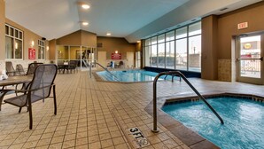 An indoor swimming pool with a 3ft depth marking, surrounded by seating areas and a view of the city. - Drury Inn & Suites Meridian (Meridian)