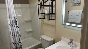 Ein Badezimmer mit Dusche, Toilette, Waschbecken und Handtuchhalter.