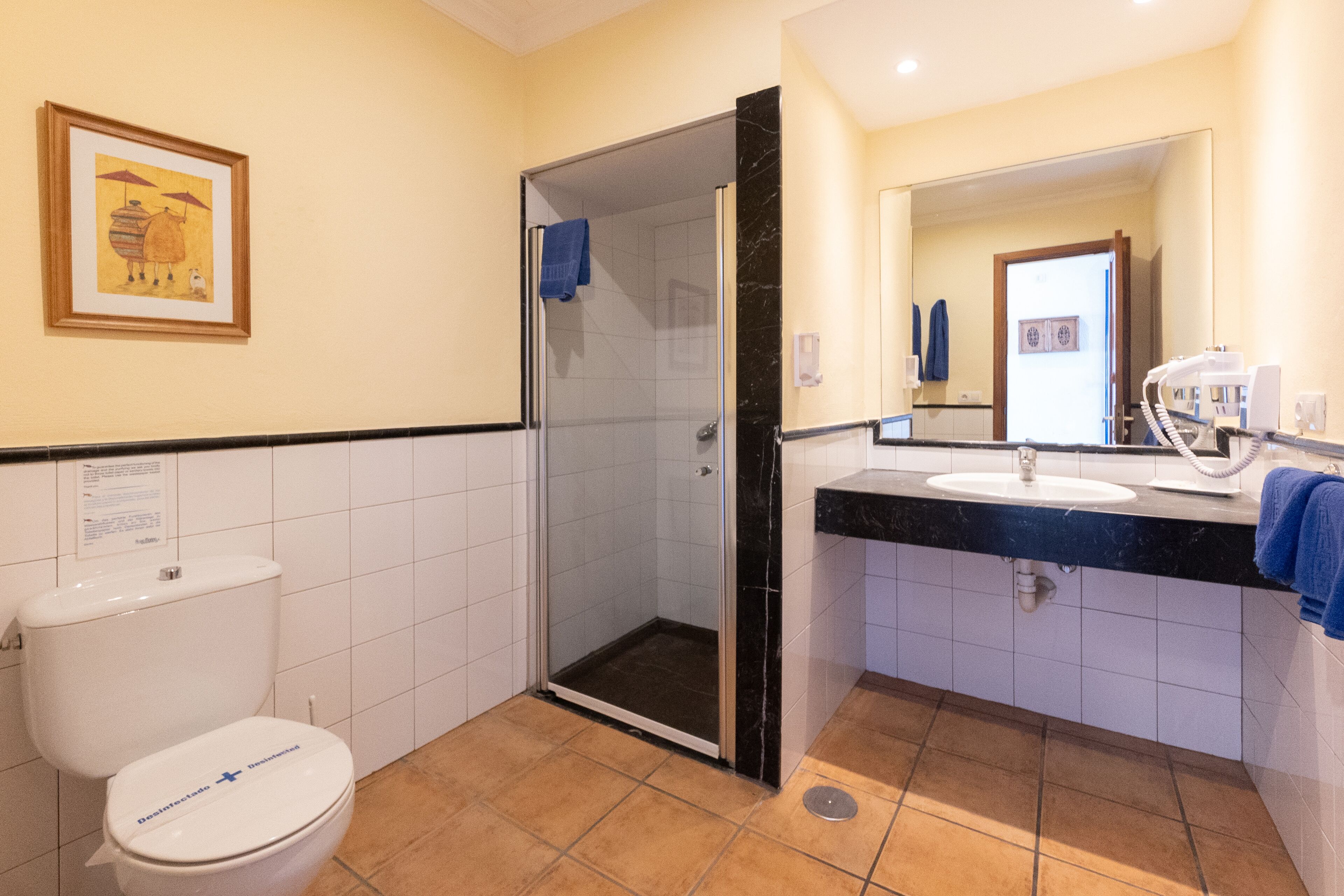 Un baño con inodoro, lavabo y ducha.