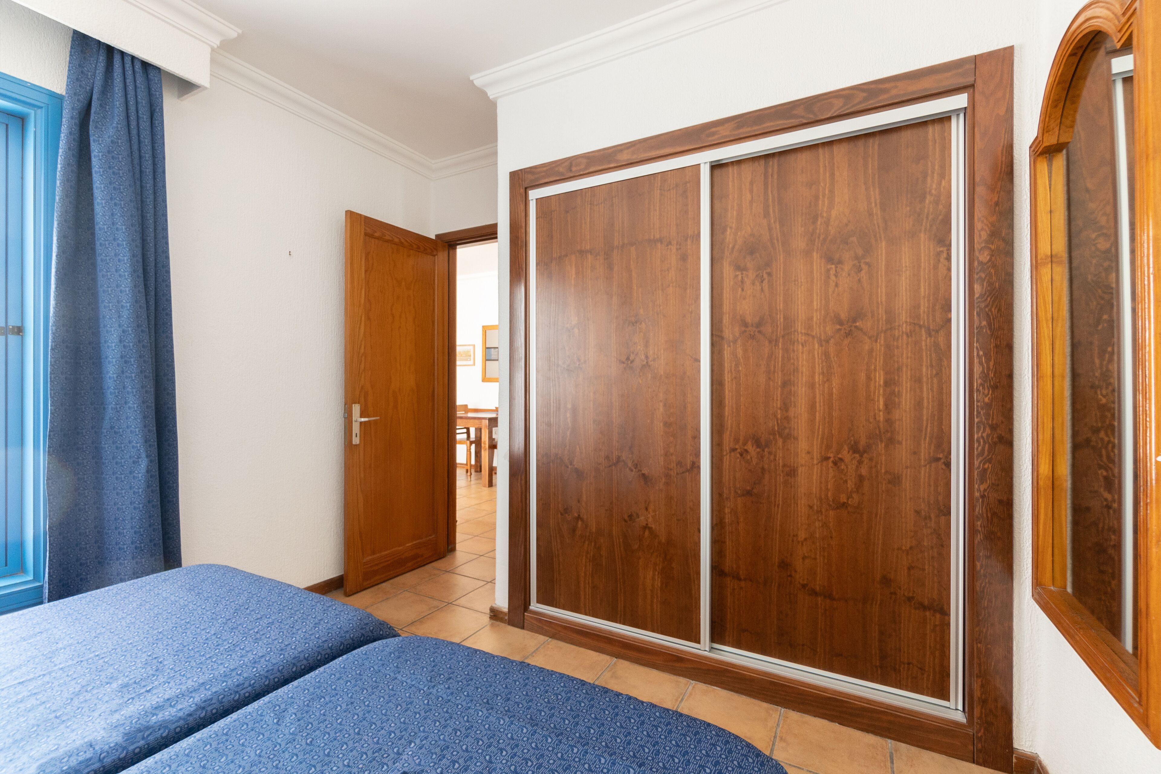 Una camera da letto con un letto, un armadio e una porta che dà su un'altra stanza.