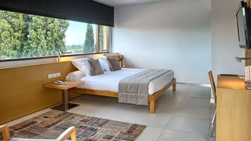 A bedroom with a bed, bedside table, and a desk with a chair.