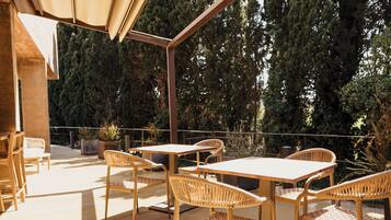 An outdoor patio with a table and chairs, surrounded by trees.