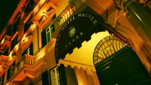 Fachada del Gran Hotel Wagner, con arquitectura clásica y señalización iluminada.