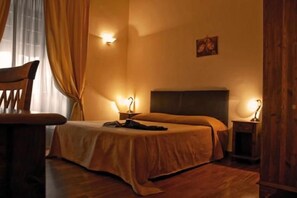 A hotel room with a bed, bedside tables, a chair, and a painting on the wall. - Stesicorea Palace (Catania)