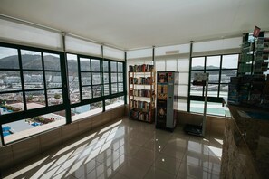 A spacious room with large windows, a bookshelf, and a vending machine. - Servatur Montebello (Mogan)