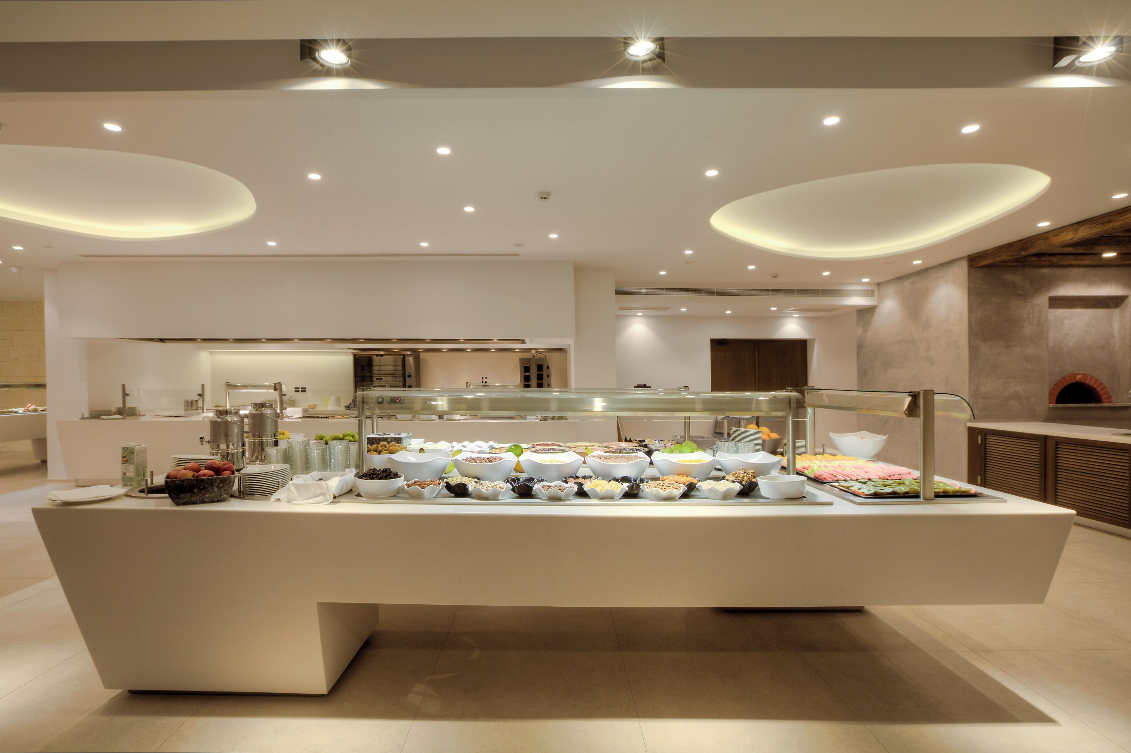 Disposición de un bufé con diferentes opciones de comida y una decoración interior moderna.