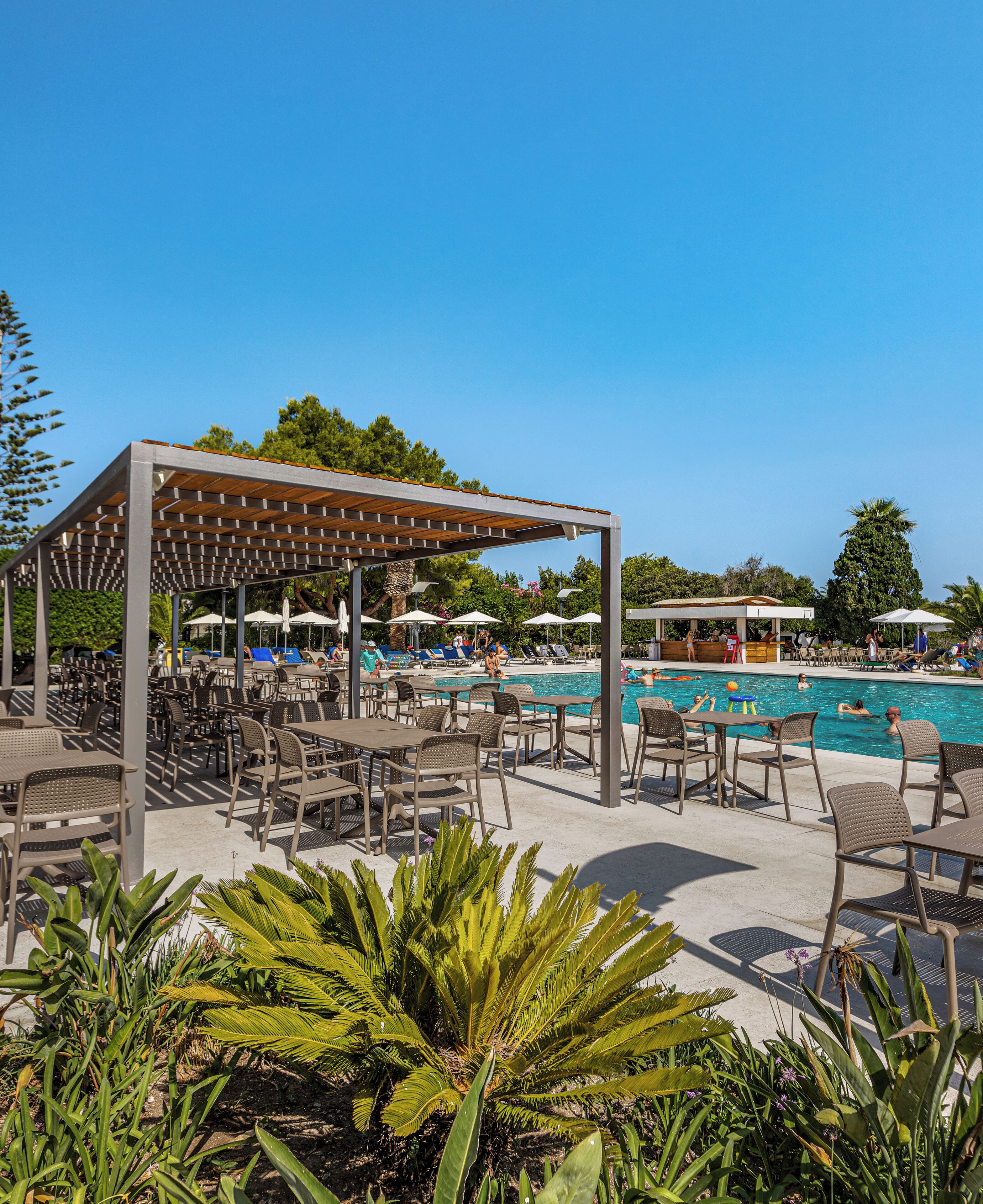 A poolside area with outdoor seating and umbrellas.