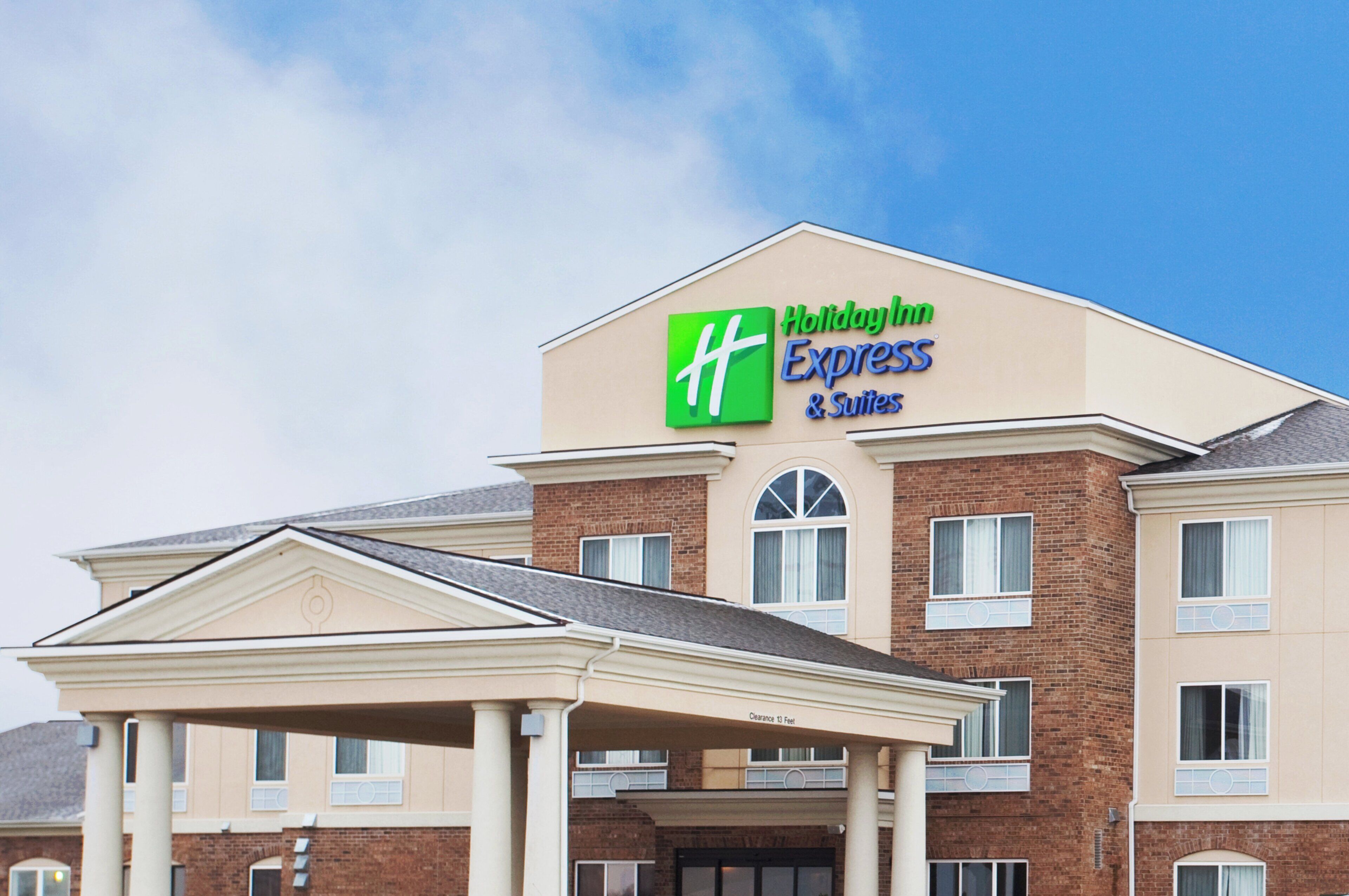 Un bâtiment de l’hôtel Holiday Inn Express & Suites, avec un ciel dégagé.