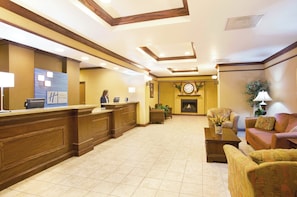 A hotel lobby with a reception desk, seating area, and a fireplace. - Holiday Inn Express & Suites Mattoon by IHG (Mattoon)