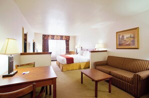 A hotel room with a bed, a sofa, a desk, a chair, and a lamp. - Holiday Inn Express & Suites Mattoon by IHG (Mattoon)