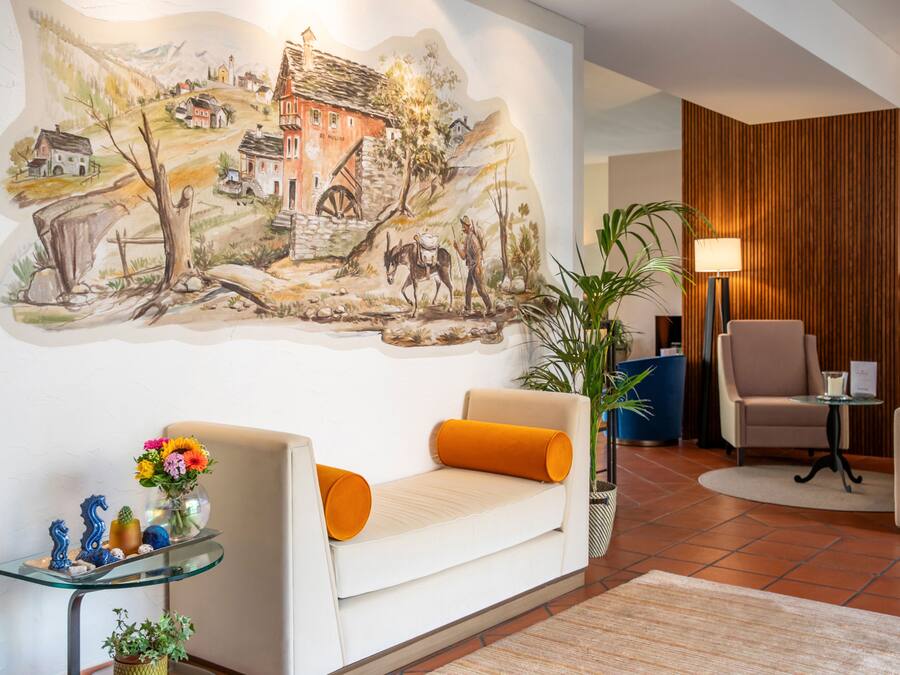 Una sala de estar moderna con un mural, un sofá, una mesa de centro y un sillón.