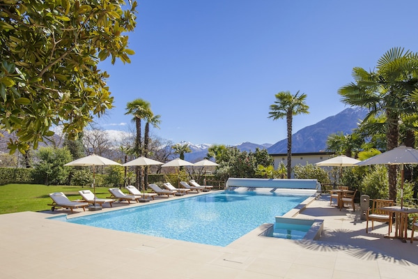 En säsongsöppen utomhuspool, parasoller och solstolar