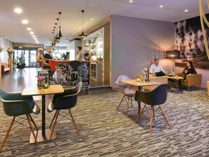 A modern hotel lobby with a bar area, seating arrangements, and a patterned carpet. - ibis Kortrijk Centrum (Kortrijk)