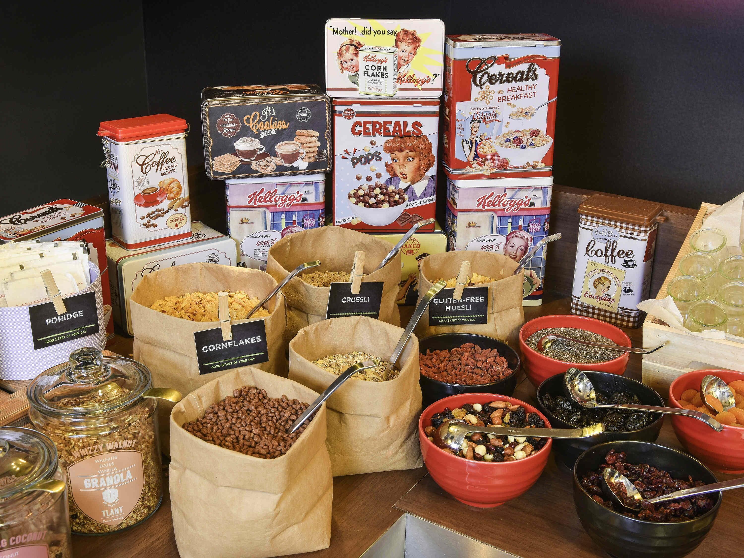 A variety of breakfast cereals, cookies, and nuts arranged on a table.