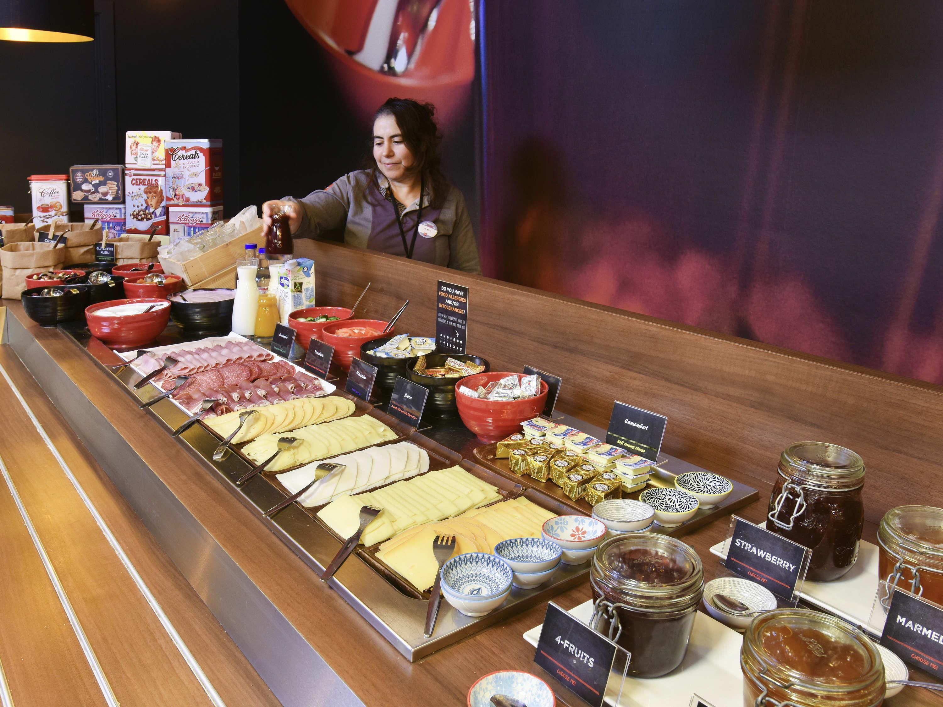 A buffet with various food options, including meats, cheeses, and condiments.