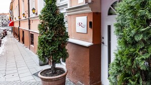 A hotel entrance with a red awning, a Christmas tree, and a sign with the hotel's name. - Rinno hotel (Vilnius)