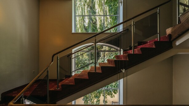 A staircase with a glass railing, leading to a lower level. - Rinno hotel (Vilnius)