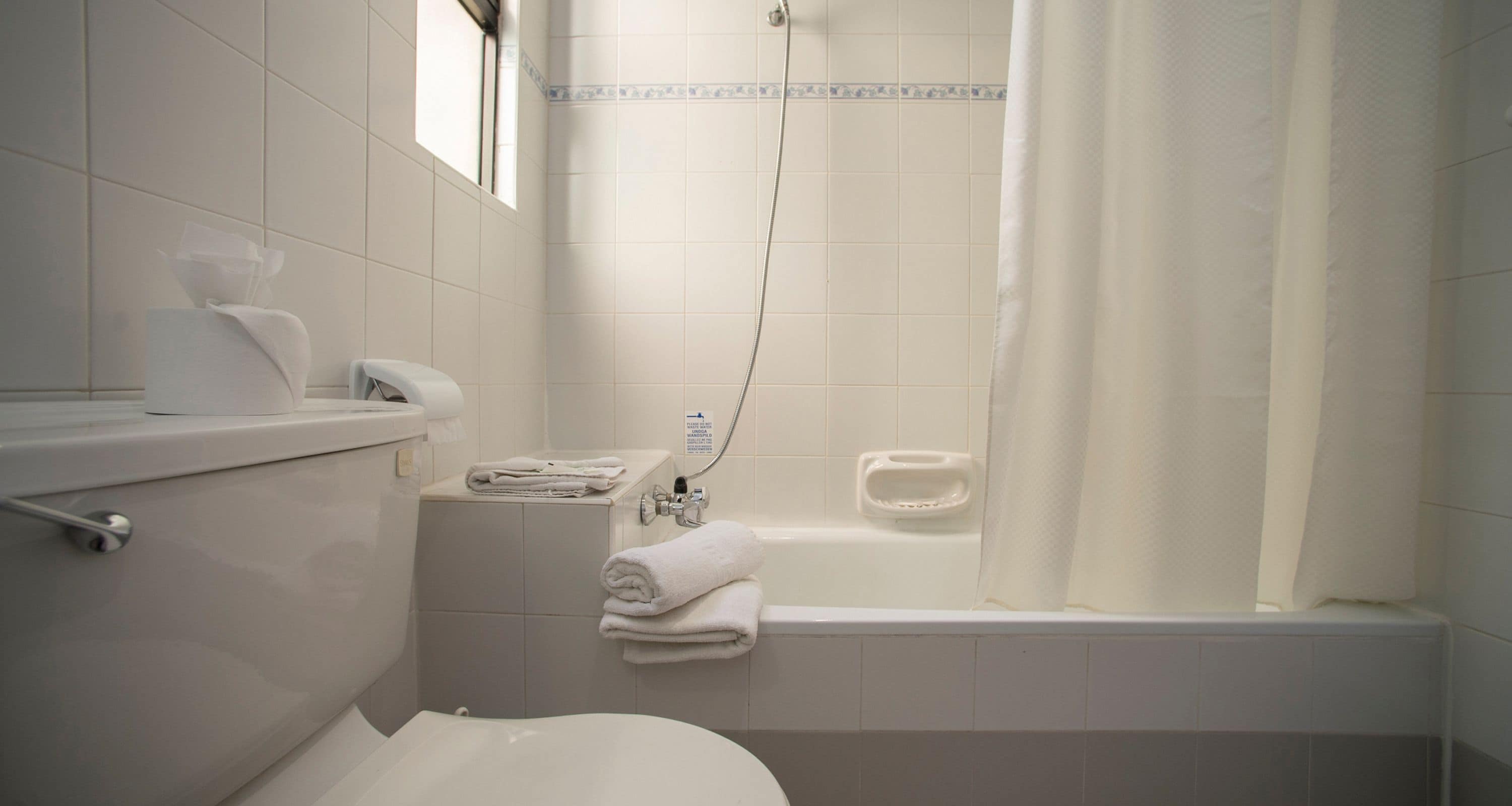 A bathroom with a toilet, a sink, a shower, and a bathtub.