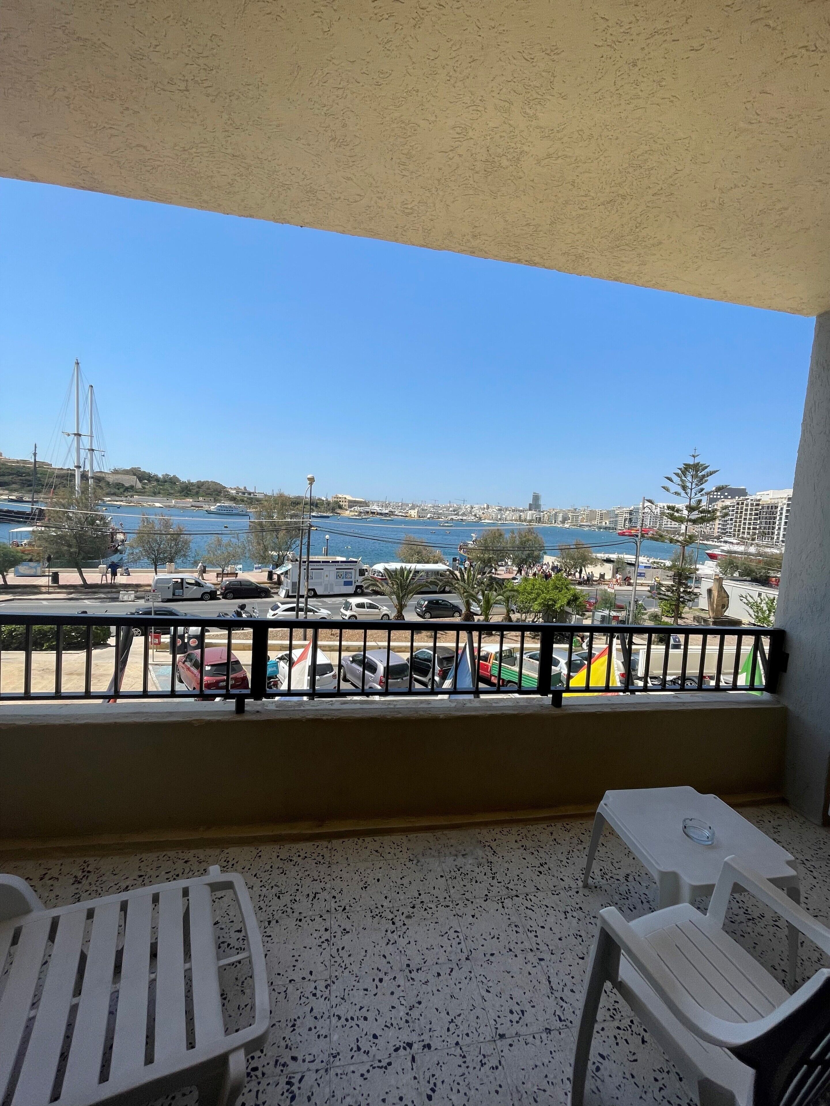 A balcony with a view of a marina and cityscape.