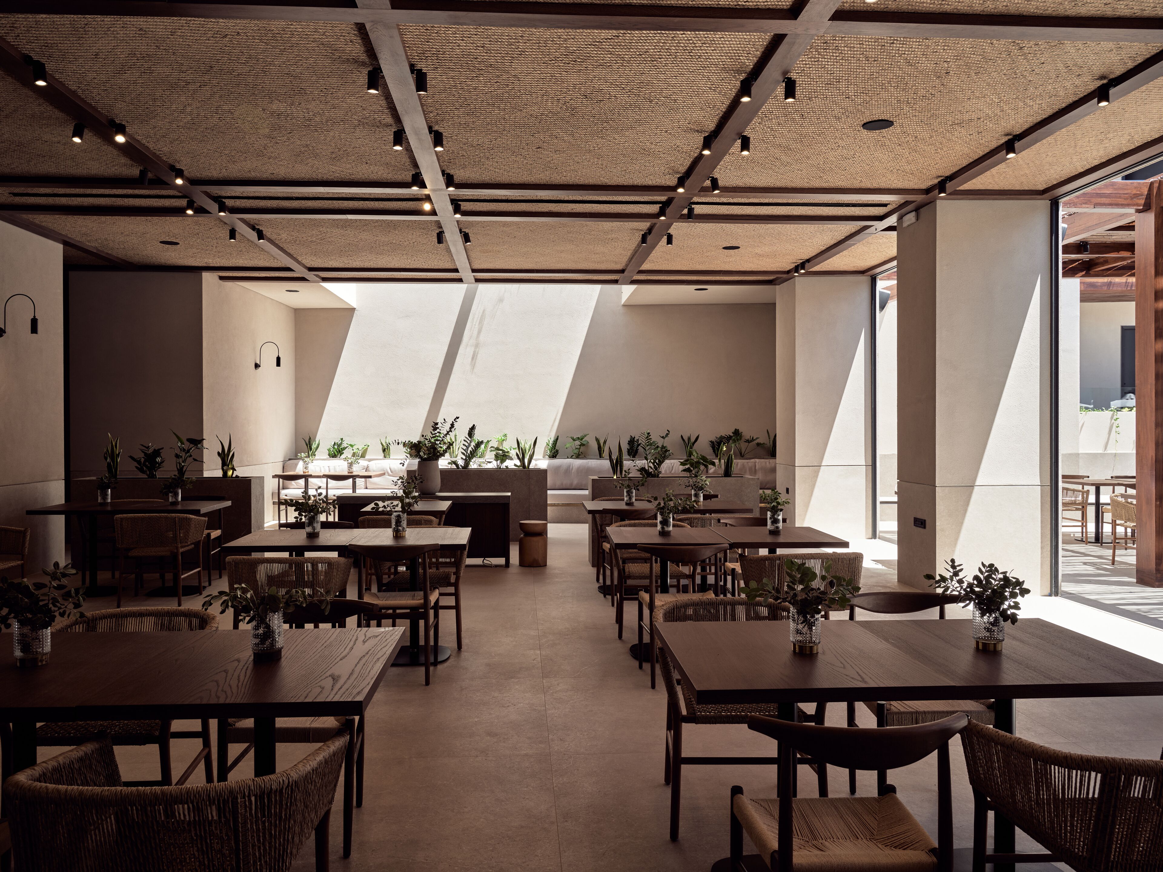 A spacious dining area with high ceilings, natural light, and modern furnishings.