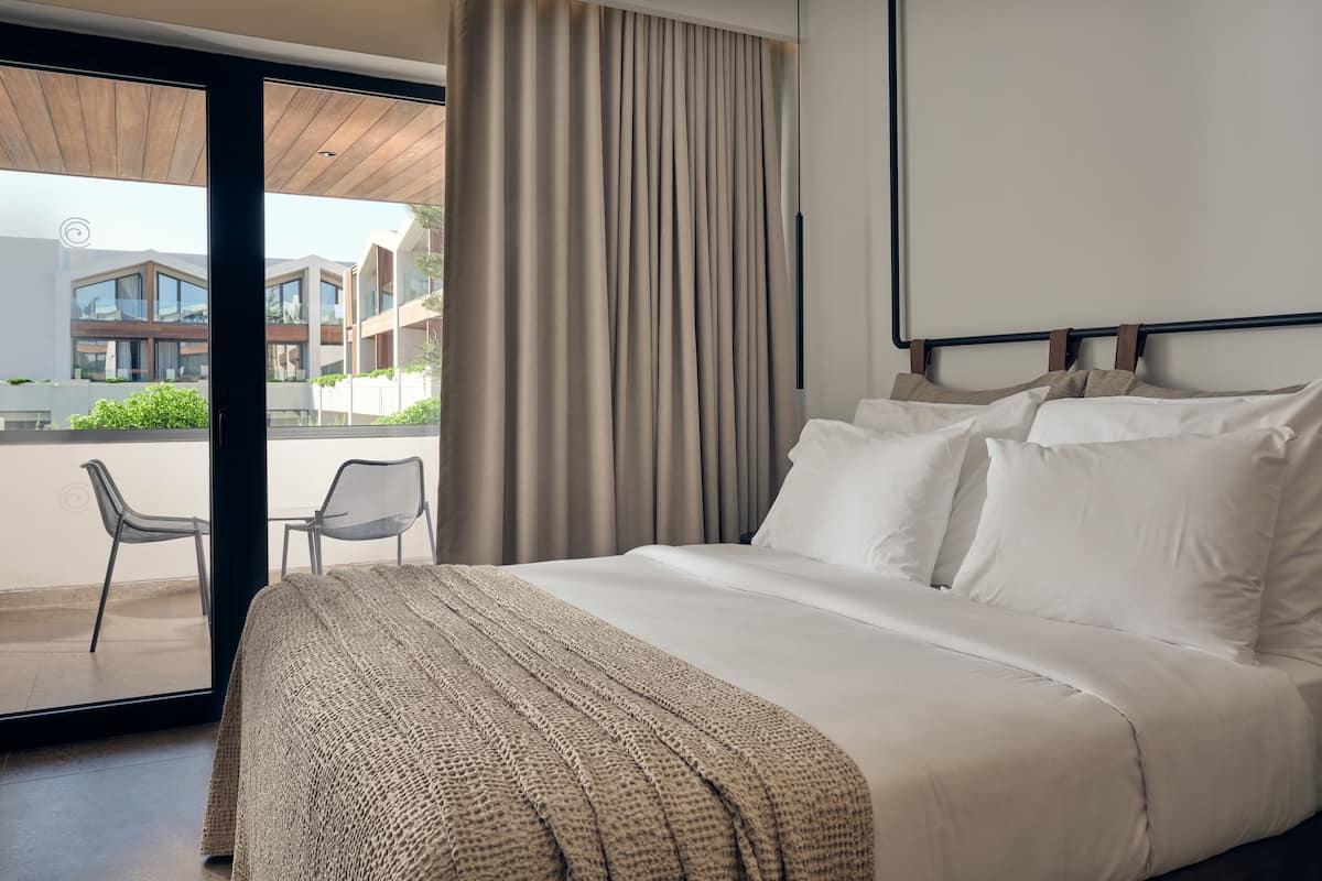 Et moderne hotelværelse med en stor seng, udsigt til balkonen og et tidssvarende design.