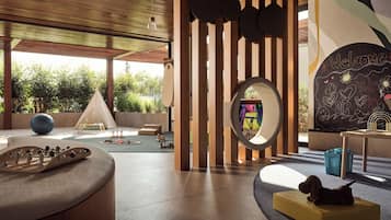 A modern play area with a wooden play structure, a large mirror, and a mural on the wall.