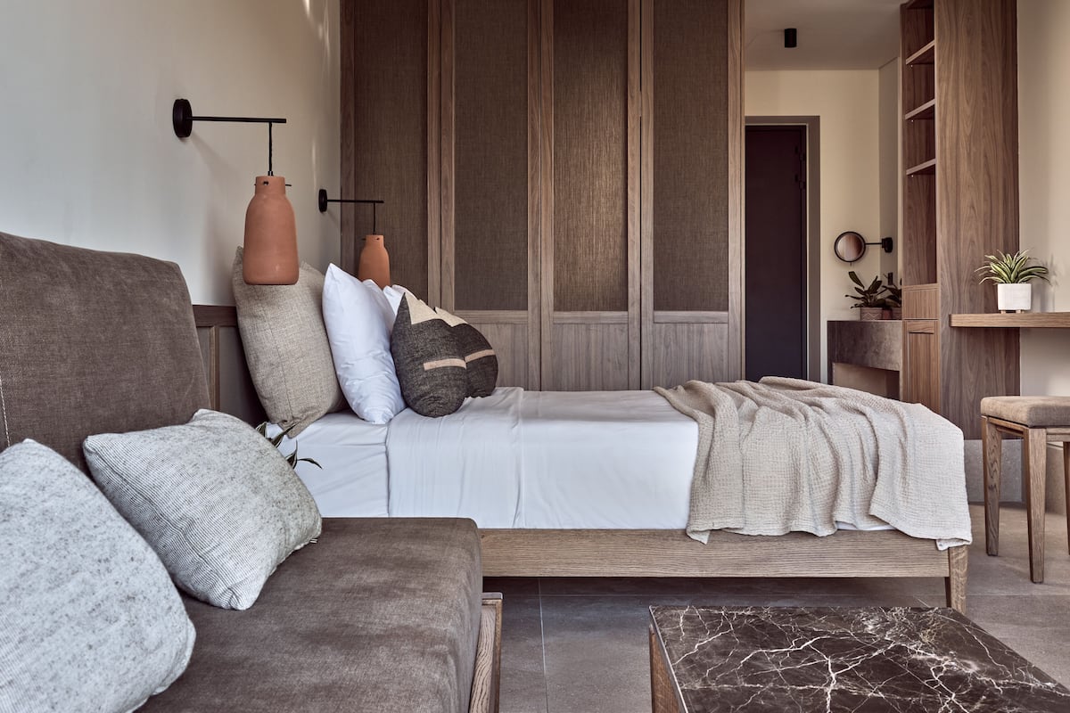 Et moderne soveværelse med seng, sofa, sofabord og et træskab.
