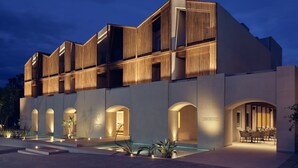 Un hotel moderno con piscina, varios balcones y un restaurante Vedema.