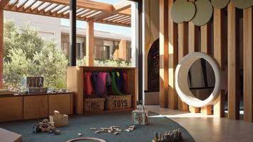 A modern interior with a wooden play area, a large window, and a circular wall decoration.